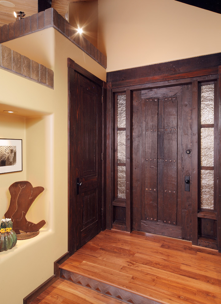 Inspiration for a large rustic medium tone wood floor foyer remodel in Phoenix with yellow walls and a dark wood front door