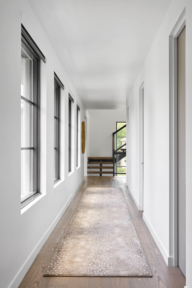 Large contemporary hallway in Dallas with white walls, dark hardwood floors and brown floor.