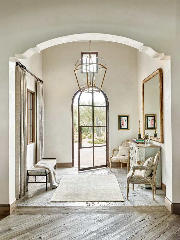 Inspiration for a mediterranean foyer in Phoenix with beige walls, medium hardwood floors, a single front door and a glass front door.