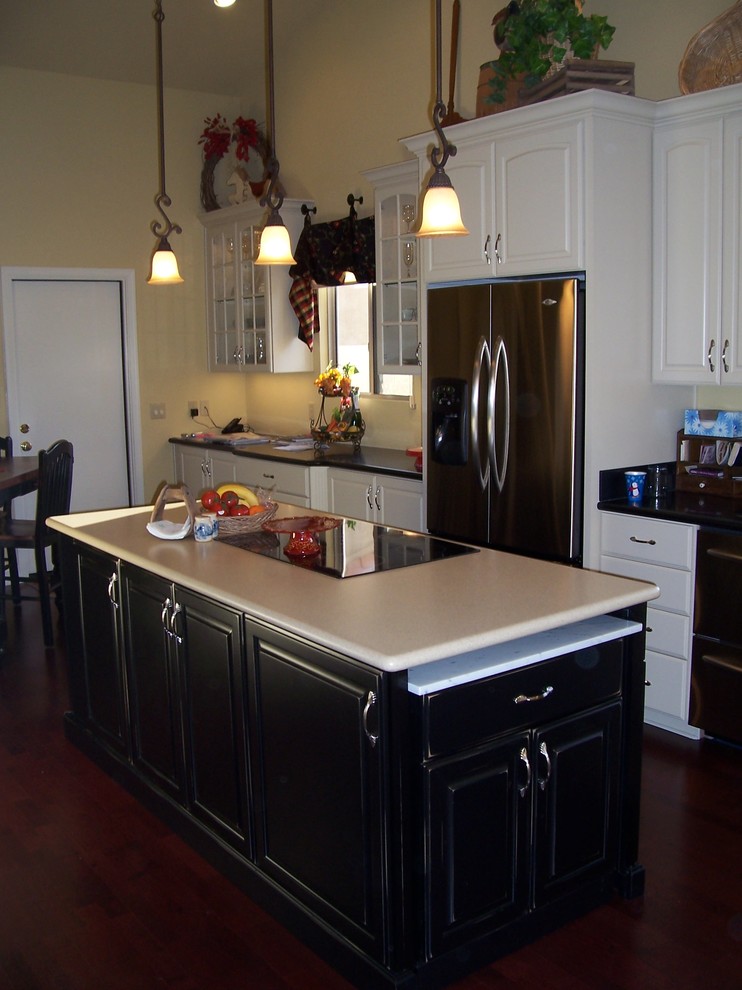 Inspiration for a mid-sized transitional u-shaped dark wood floor eat-in kitchen remodel in Phoenix with a double-bowl sink, raised-panel cabinets, dark wood cabinets, wood countertops, white backsplash, subway tile backsplash, white appliances and no island