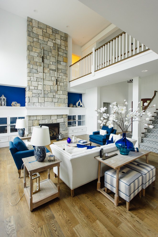 Large beach style open concept and formal medium tone wood floor living room photo in Chicago with white walls, a standard fireplace, a stone fireplace and no tv