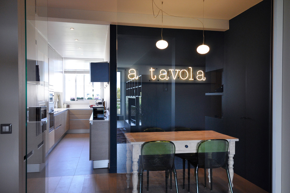 Inspiration for a mid-sized contemporary u-shaped eat-in kitchen in Paris with light wood cabinets and no island.