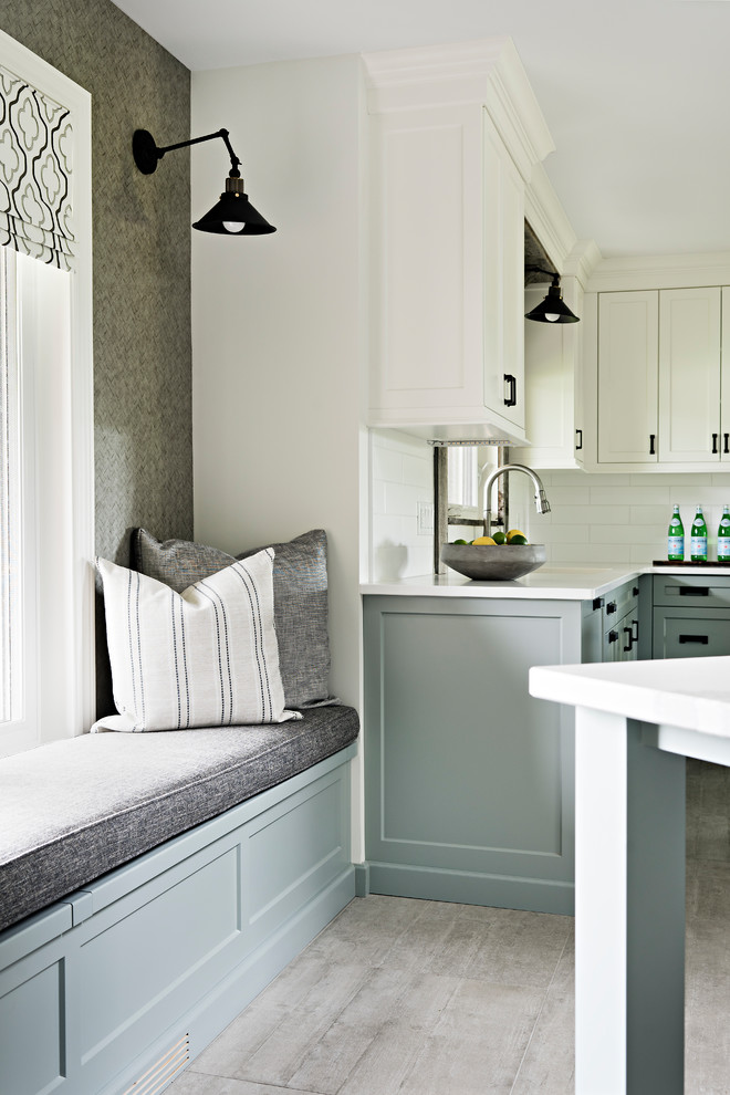 Mid-sized transitional porcelain tile and beige floor eat-in kitchen photo in Toronto with a single-bowl sink, shaker cabinets, white cabinets, quartzite countertops, white backsplash, subway tile backsplash, stainless steel appliances, an island and white countertops