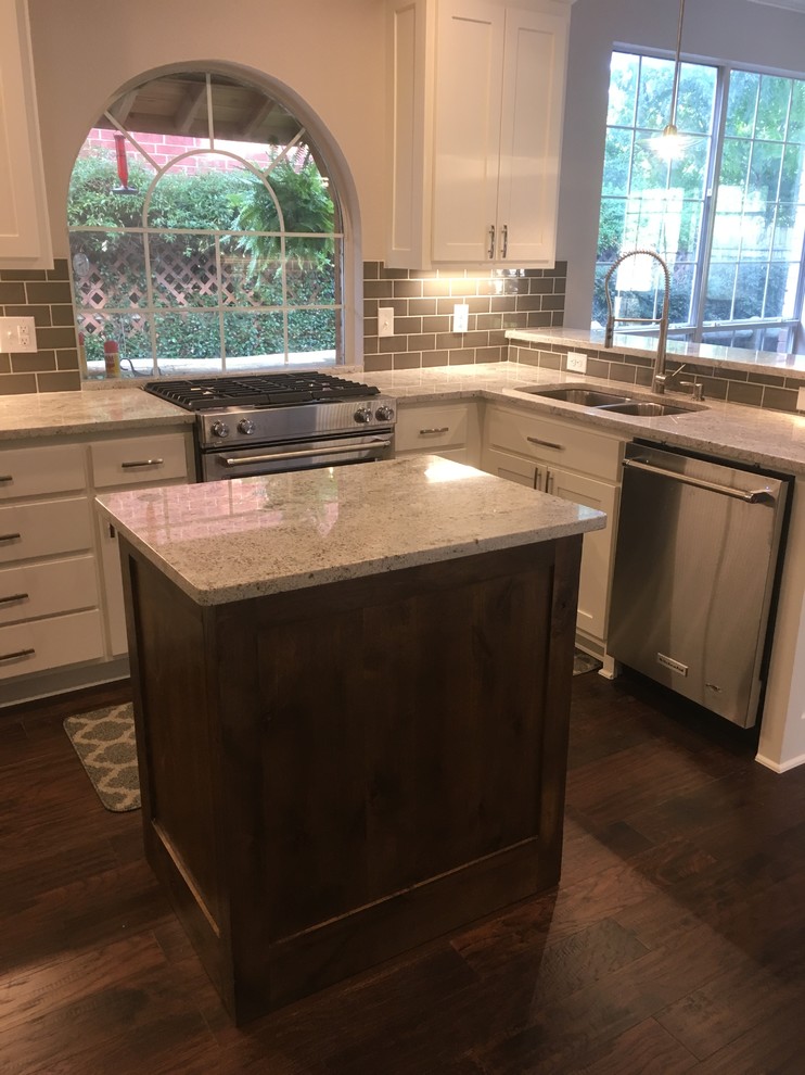 Eat-in kitchen - mid-sized transitional u-shaped dark wood floor and blue floor eat-in kitchen idea in Dallas with a double-bowl sink, shaker cabinets, white cabinets, granite countertops, gray backsplash, subway tile backsplash, stainless steel appliances and an island