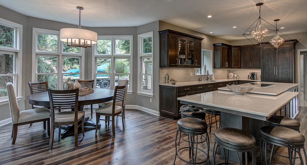 Eat-in kitchen - large transitional l-shaped medium tone wood floor and brown floor eat-in kitchen idea with an undermount sink, flat-panel cabinets, dark wood cabinets, marble countertops, white backsplash, ceramic backsplash, stainless steel appliances, an island and white countertops