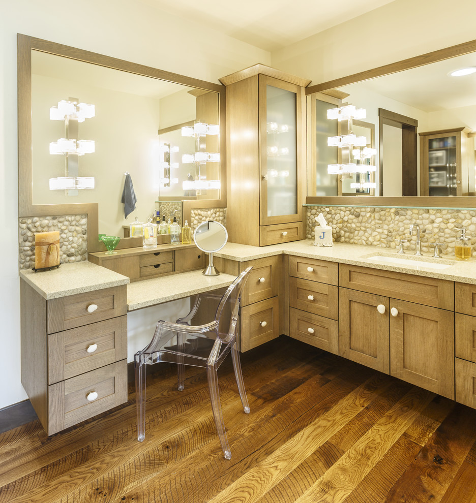Photo of a transitional master bathroom in Atlanta with shaker cabinets, medium wood cabinets, pebble tile, medium hardwood floors, an undermount sink, brown floor and beige benchtops.