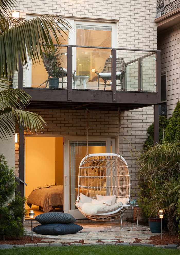 Photo of a small midcentury backyard patio in San Francisco with natural stone pavers and a roof extension.