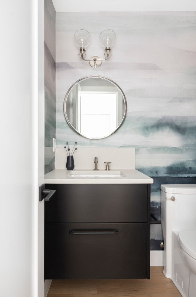 Small minimalist light wood floor and wallpaper powder room photo in Portland with flat-panel cabinets, black cabinets, a one-piece toilet, multicolored walls, an undermount sink, quartz countertops, white countertops and a floating vanity