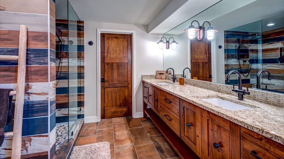 Design ideas for a large country master bathroom in Denver with shaker cabinets, medium wood cabinets, an alcove shower, multi-coloured tile, stone tile, beige walls, terra-cotta floors, an undermount sink and granite benchtops.