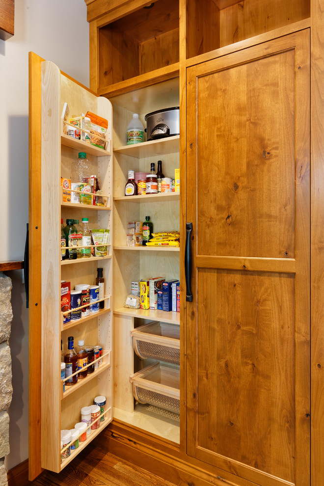 Photo of a country kitchen pantry in Cincinnati with flat-panel cabinets, medium wood cabinets, granite benchtops, stainless steel appliances, medium hardwood floors, with island and brown floor.