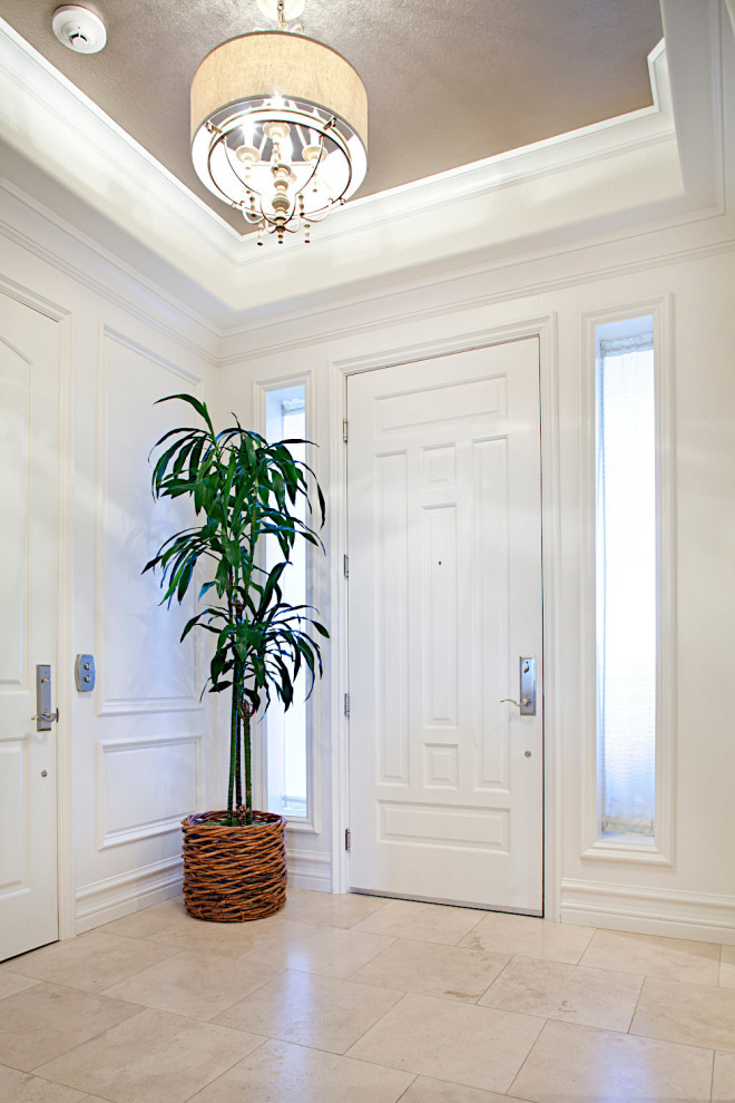 Inspiration for a mid-sized beach style foyer in Las Vegas with white walls, travertine floors, a single front door, a white front door, beige floor, wallpaper and decorative wall panelling.