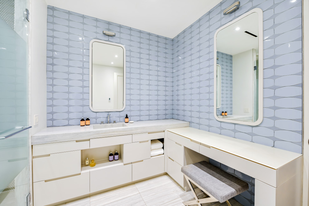 Modern inredning av ett grå grått en-suite badrum, med släta luckor, vita skåp, en hörndusch, en toalettstol med hel cisternkåpa, blå kakel, keramikplattor, blå väggar, klinkergolv i keramik, ett integrerad handfat, marmorbänkskiva, grått golv och dusch med gångjärnsdörr