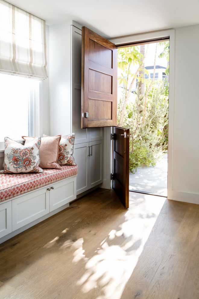 Inspiration for a mid-sized beach style mudroom in Los Angeles with white walls, light hardwood floors, a dutch front door, a medium wood front door and beige floor.