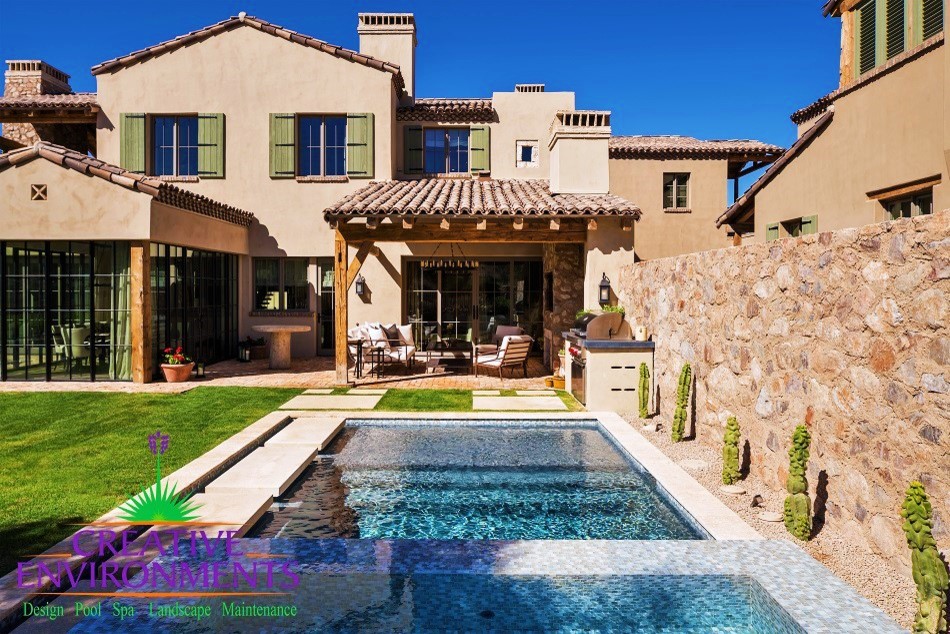 Example of a mid-sized mountain style backyard decomposed granite and rectangular pool fountain design in Phoenix