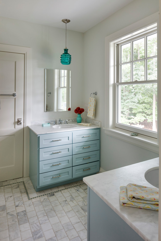 Design ideas for a mid-sized contemporary kids bathroom in Boston with recessed-panel cabinets, blue cabinets, a one-piece toilet, blue walls, ceramic floors, a console sink, marble benchtops and white floor.