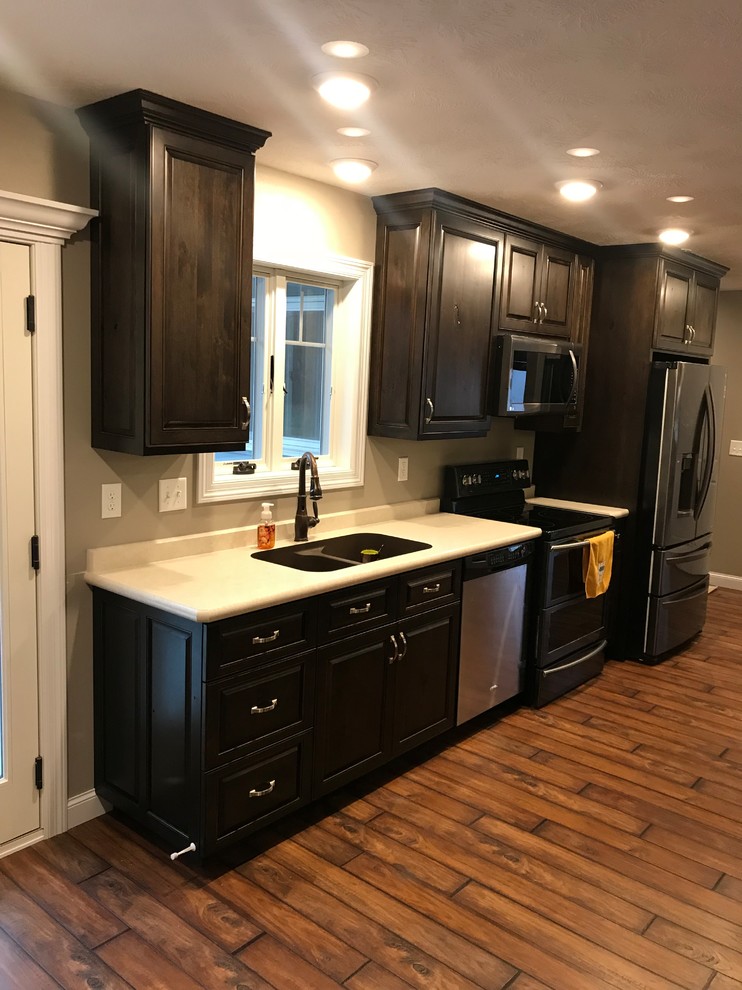 Example of a classic kitchen design with raised-panel cabinets, laminate countertops and stainless steel appliances