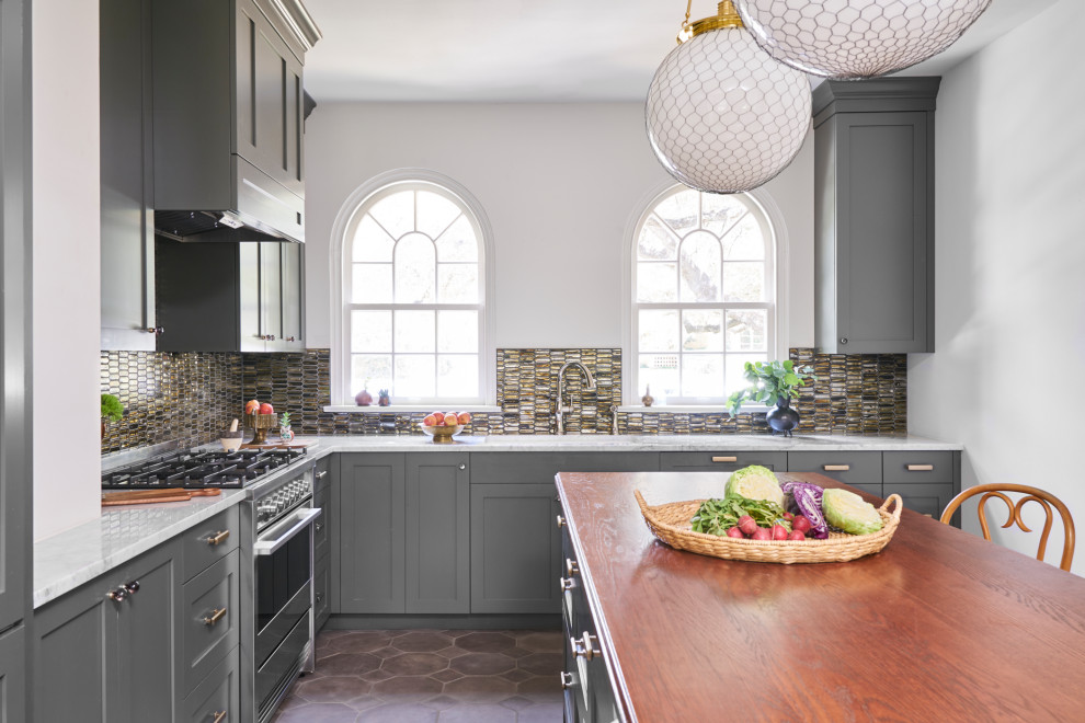 Design ideas for a mid-sized traditional kitchen in Other with an undermount sink, shaker cabinets, green cabinets, wood benchtops, multi-coloured splashback, glass tile splashback, stainless steel appliances, terra-cotta floors, with island, brown floor and brown benchtop.