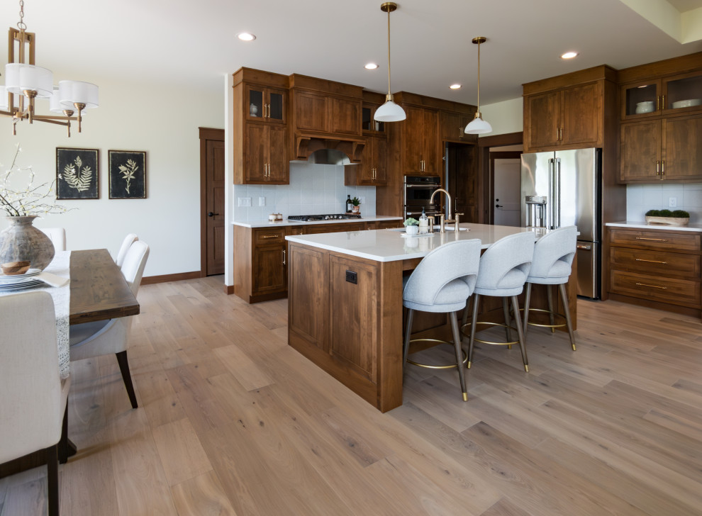 Eat-in kitchen - transitional galley light wood floor and beige floor eat-in kitchen idea with an undermount sink, shaker cabinets, medium tone wood cabinets, quartz countertops, white backsplash, ceramic backsplash, an island and white countertops