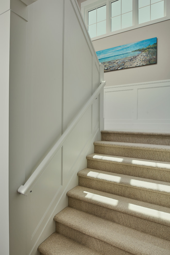 This is an example of a large transitional carpeted u-shaped staircase in Grand Rapids with wood risers.