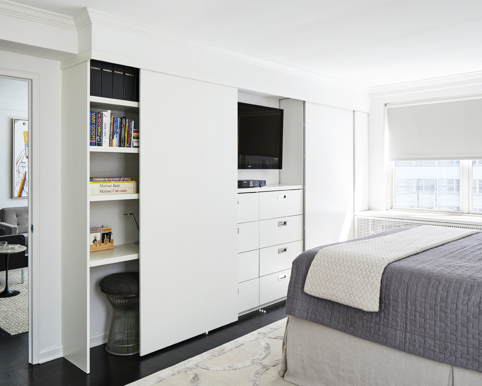 This is an example of a mid-sized modern master bedroom in New York with white walls, dark hardwood floors and black floor.