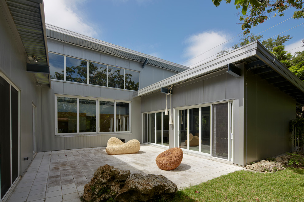 Mid-sized urban courtyard concrete paver patio photo in Miami with no cover
