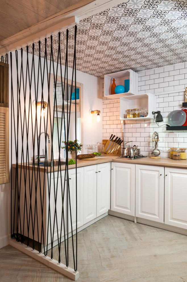Inspiration for a scandinavian kitchen in Moscow with a drop-in sink, raised-panel cabinets, white cabinets, wood benchtops, white splashback and subway tile splashback.