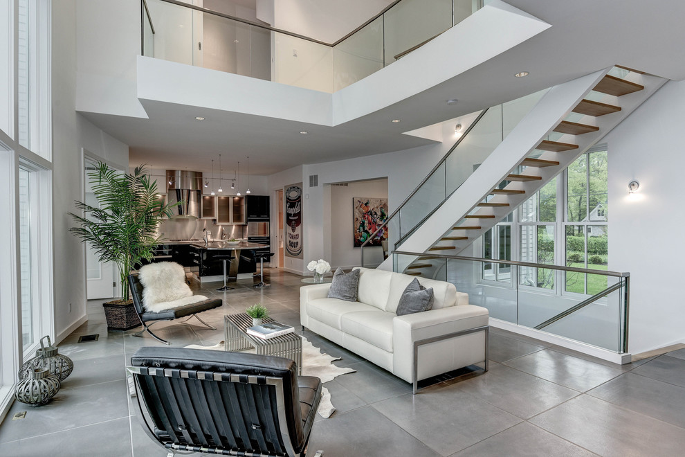 Large contemporary formal open concept living room in DC Metro with white walls, concrete floors, a standard fireplace, a tile fireplace surround, no tv and grey floor.