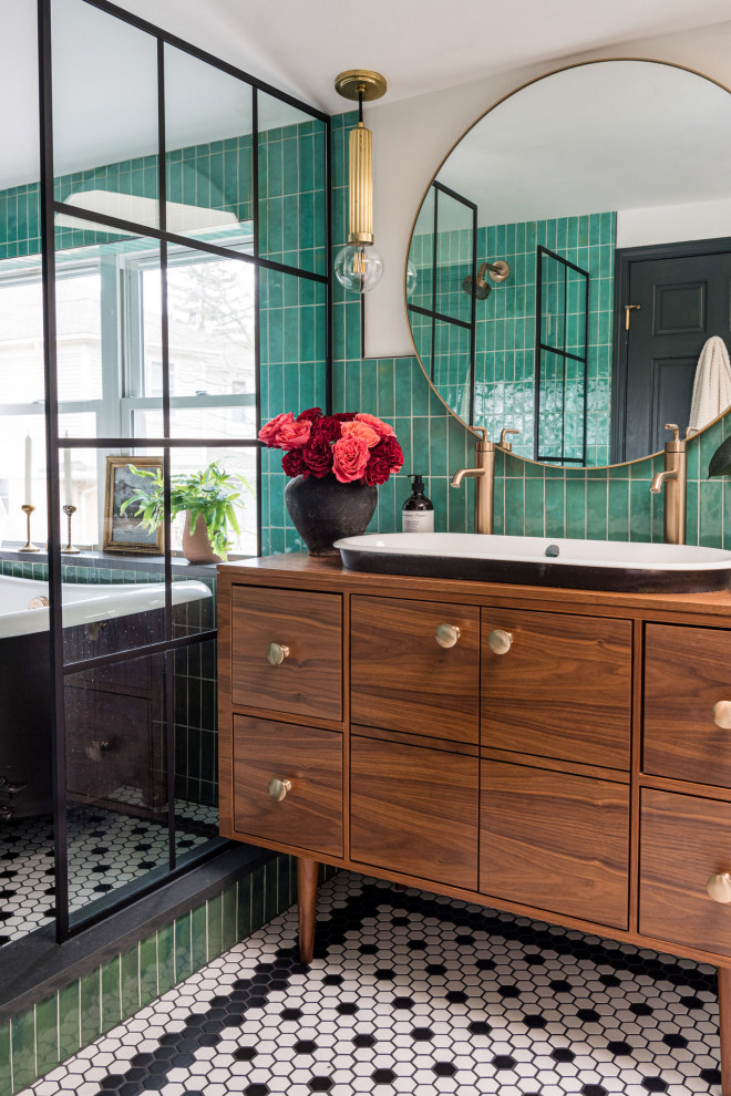 This is an example of a mid-sized eclectic master bathroom in Chicago with flat-panel cabinets, medium wood cabinets, a claw-foot tub, a shower/bathtub combo, green tile, porcelain tile, white walls, porcelain floors, a drop-in sink, wood benchtops, black floor, an open shower, brown benchtops, a niche, a double vanity and a freestanding vanity.