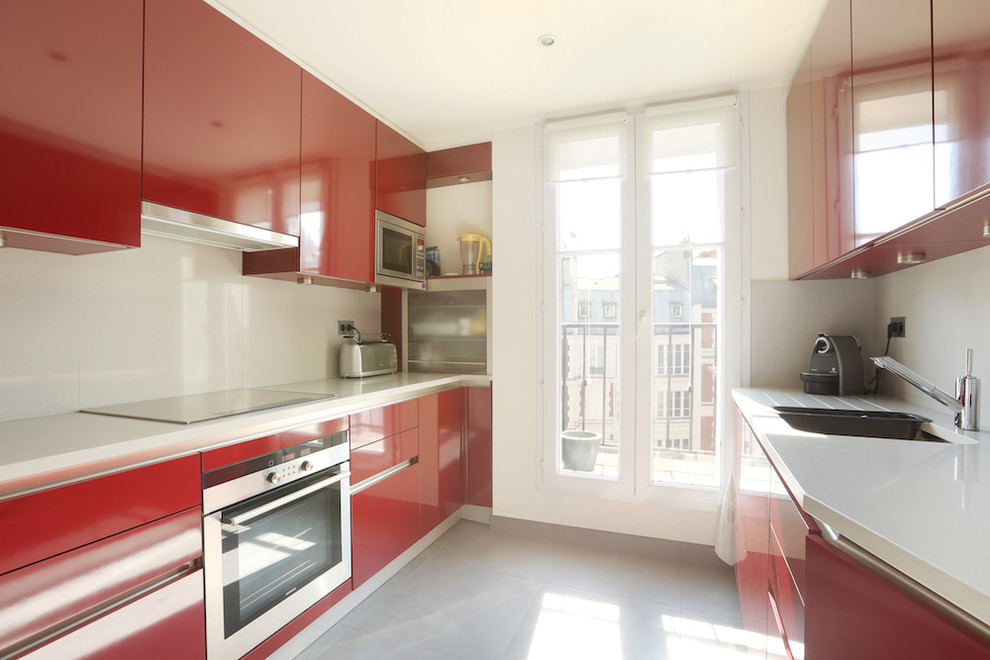 Small modern single-wall separate kitchen in Paris with an undermount sink, flat-panel cabinets, red cabinets, quartzite benchtops, beige splashback, stainless steel appliances, porcelain floors, no island, grey floor and beige benchtop.