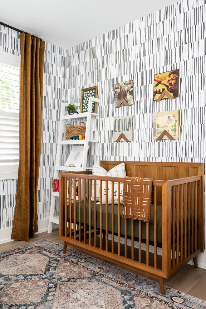 Diseño de habitación de bebé neutra ecléctica con paredes multicolor y papel pintado