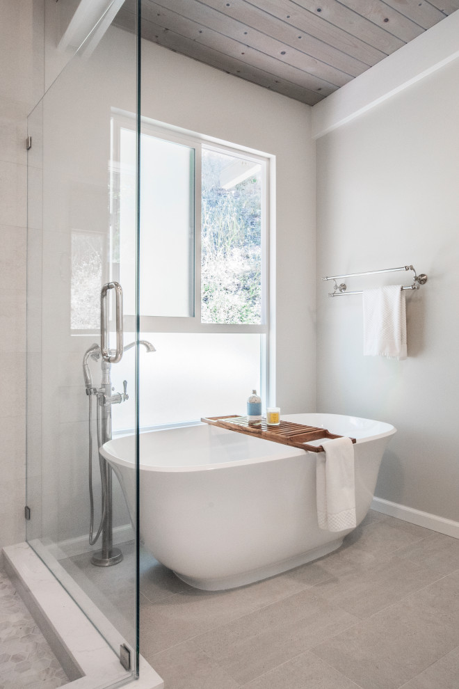 Photo of a large transitional master bathroom in San Francisco with recessed-panel cabinets, blue cabinets, a freestanding tub, a corner shower, a one-piece toilet, beige tile, porcelain tile, beige walls, porcelain floors, an undermount sink, engineered quartz benchtops, beige floor, a hinged shower door, white benchtops, a niche, a double vanity, a built-in vanity and wood.