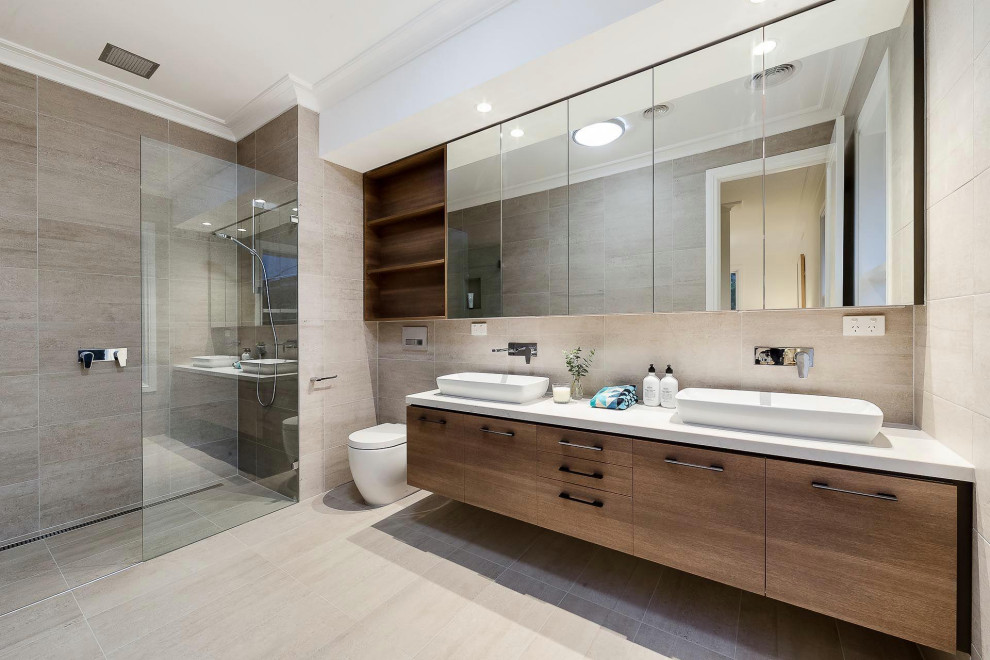 Photo of a mid-sized midcentury master bathroom in Los Angeles with flat-panel cabinets, light wood cabinets, a freestanding tub, a corner shower, a one-piece toilet, beige tile, ceramic tile, beige walls, ceramic floors, a drop-in sink, quartzite benchtops, beige floor, white benchtops, a double vanity, a floating vanity, coffered and panelled walls.