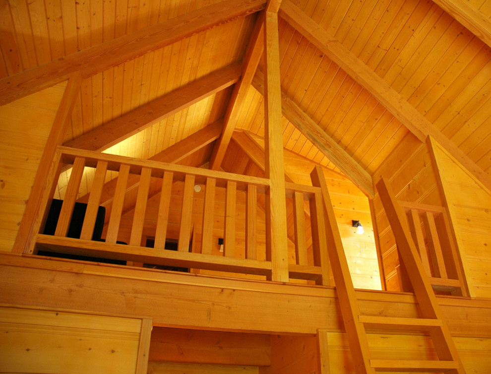 This is an example of an expansive country loft-style bedroom in Other with brown walls, light hardwood floors and brown floor.