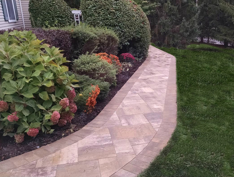 Inspiration for a mid-sized traditional backyard full sun formal garden for spring in New York with a garden path and natural stone pavers.
