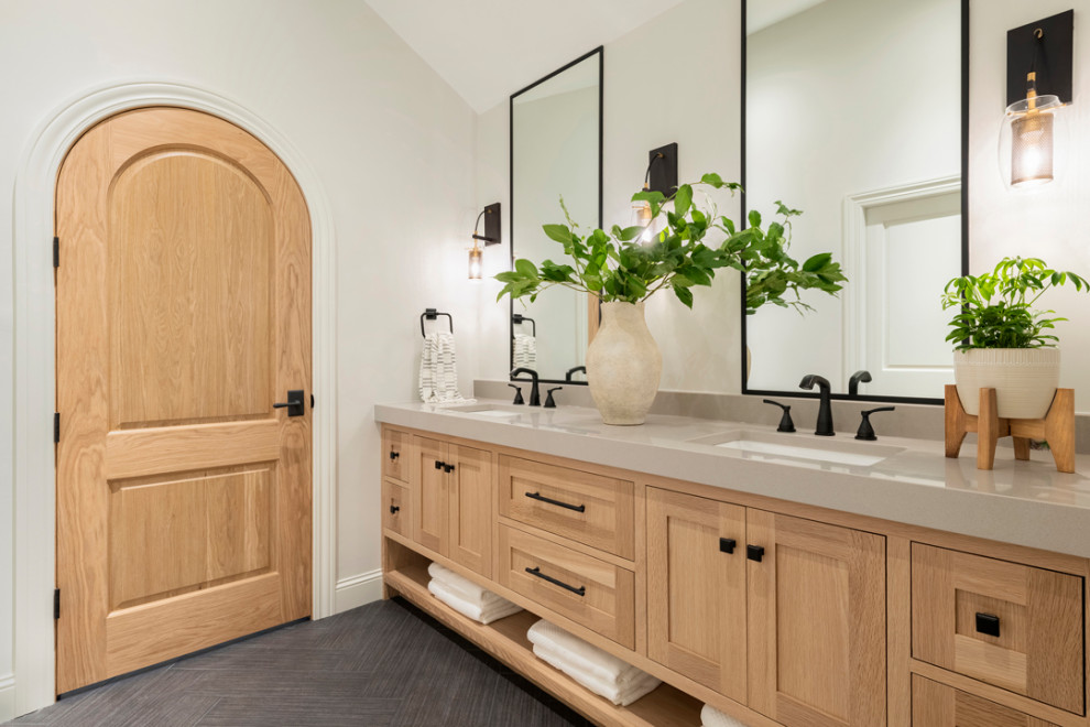 Photo of a transitional bathroom in Minneapolis with light wood cabinets, grey floor, a shower seat, a double vanity, vaulted, shaker cabinets, white walls, an undermount sink, grey benchtops and a built-in vanity.