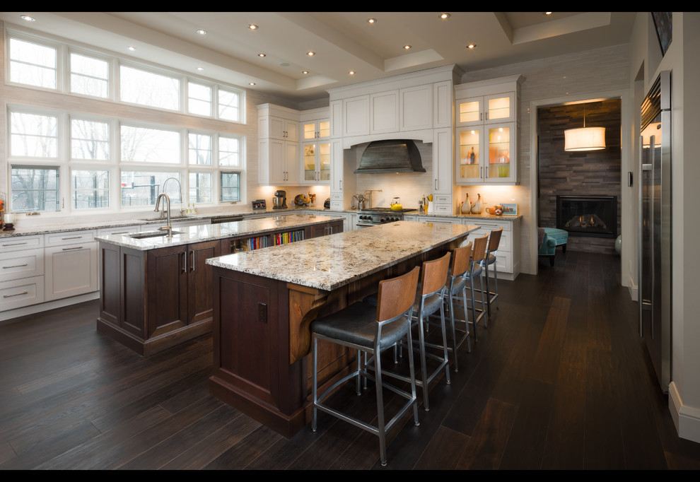 Transitional galley dark wood floor eat-in kitchen photo in Calgary with an undermount sink, beaded inset cabinets, white cabinets, granite countertops, beige backsplash, mosaic tile backsplash, stainless steel appliances and two islands