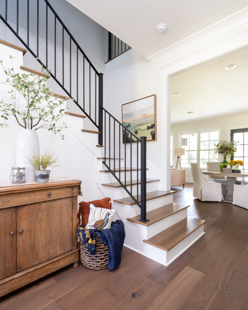 Country medium tone wood floor, brown floor and shiplap wall foyer photo in Little Rock with white walls