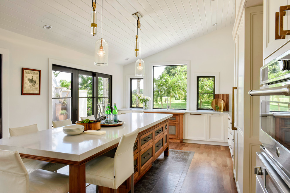 Inspiration for a mid-sized transitional l-shaped medium tone wood floor and brown floor enclosed kitchen remodel with recessed-panel cabinets, beige cabinets, stainless steel appliances, an island and white countertops