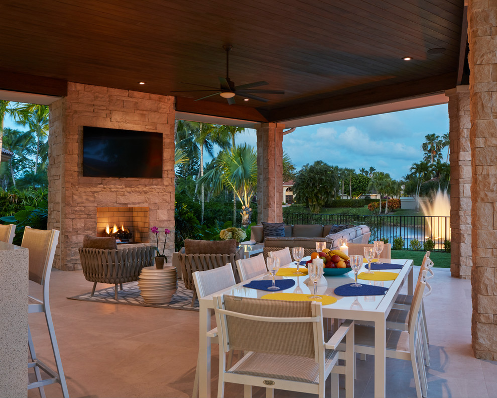Inspiration for a contemporary backyard patio in Miami with a roof extension and with fireplace.