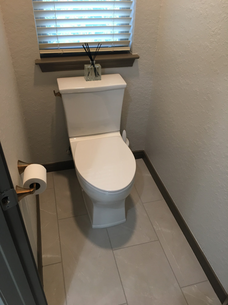 This is an example of a medium sized classic cloakroom in Austin with raised-panel cabinets, grey cabinets, a two-piece toilet, grey tiles, porcelain flooring, a submerged sink, engineered stone worktops, grey floors, beige worktops and a built in vanity unit.