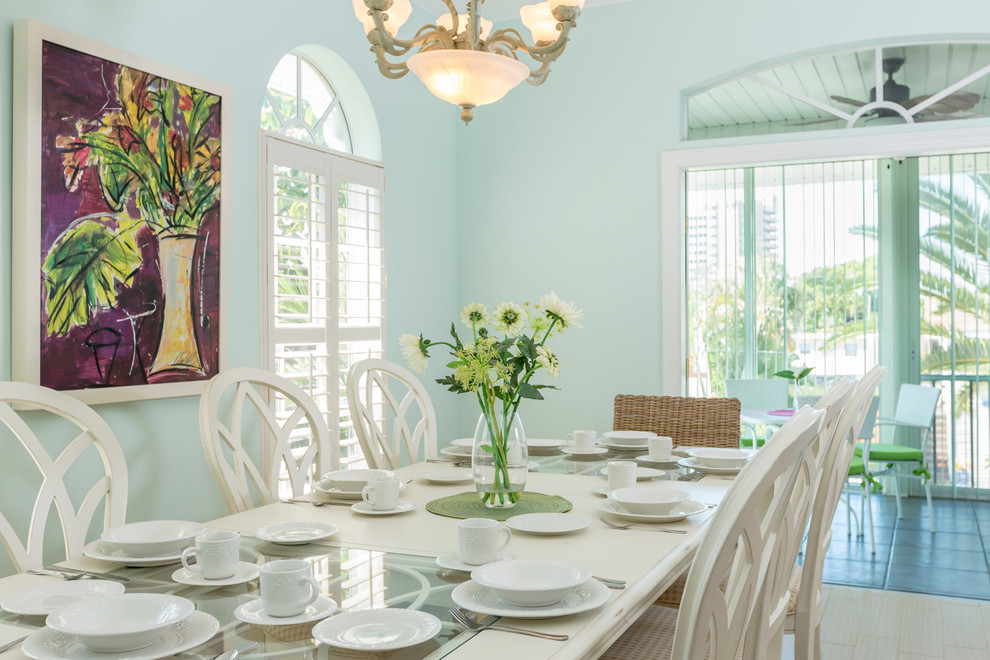 This is an example of a tropical dining room in Other with blue walls.