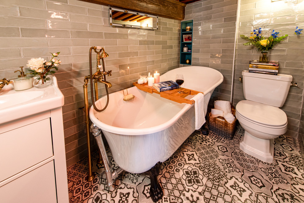 This is an example of a small midcentury master bathroom in Lyon with blue cabinets, a claw-foot tub, a shower/bathtub combo, a one-piece toilet, green tile, ceramic tile, green walls, cement tiles, a trough sink, solid surface benchtops, black floor, an open shower, white benchtops, a built-in vanity and exposed beam.