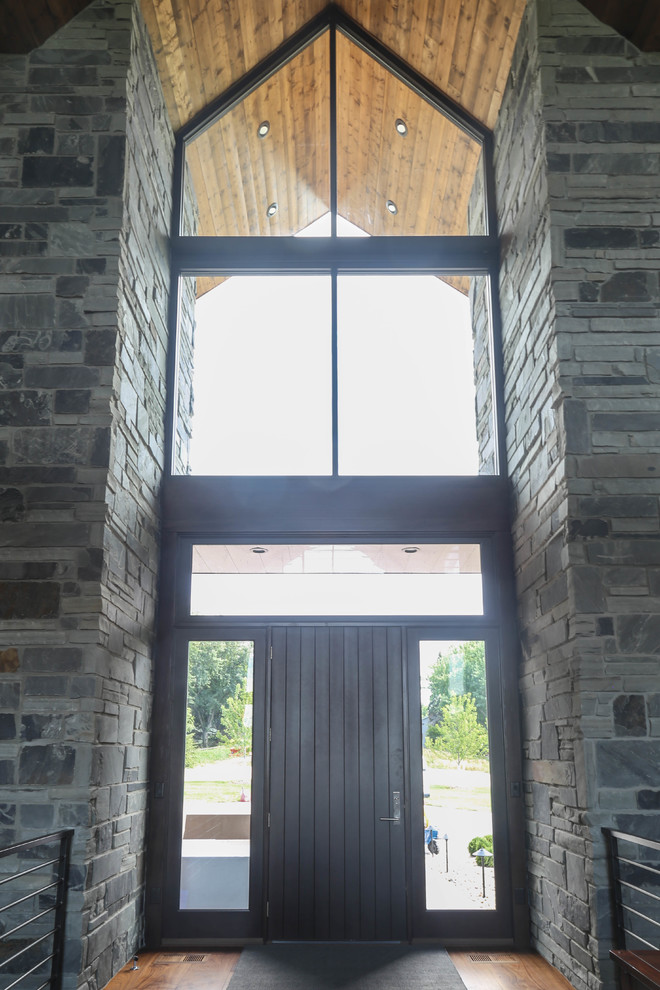 Inspiration for a large medium tone wood floor and brown floor front door remodel with white walls and a dark wood front door