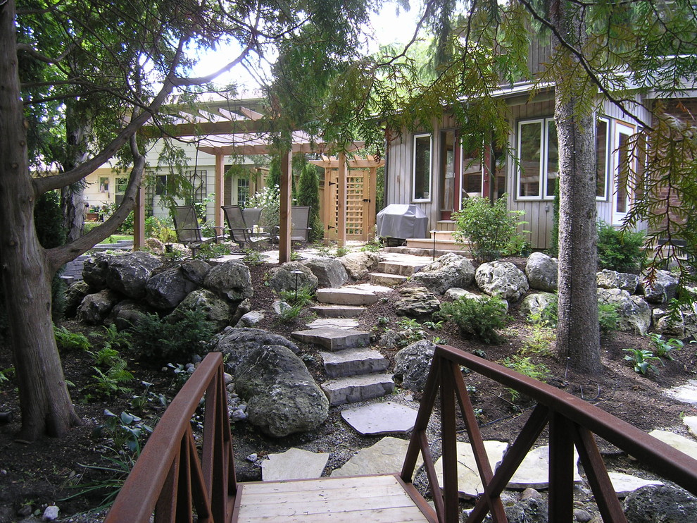 Inspiration for a large contemporary backyard full sun garden in Toronto with natural stone pavers.