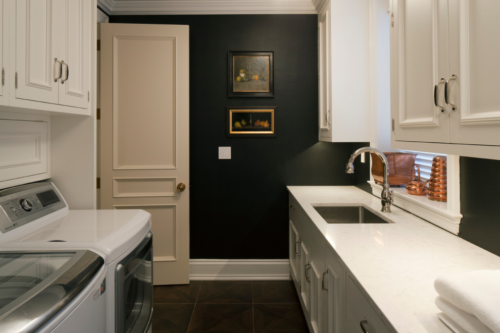 Design ideas for a transitional galley utility room in Baltimore with an undermount sink, beaded inset cabinets, white cabinets, black walls, a side-by-side washer and dryer and white benchtop.