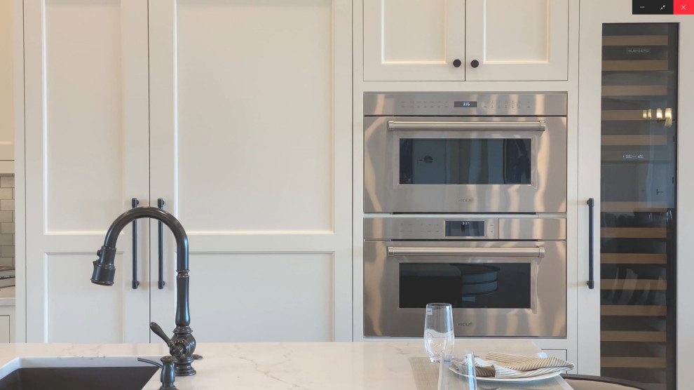 Example of a large transitional l-shaped light wood floor kitchen pantry design in Boston with an integrated sink, recessed-panel cabinets, white cabinets, quartz countertops, brown backsplash, ceramic backsplash, stainless steel appliances, an island and yellow countertops