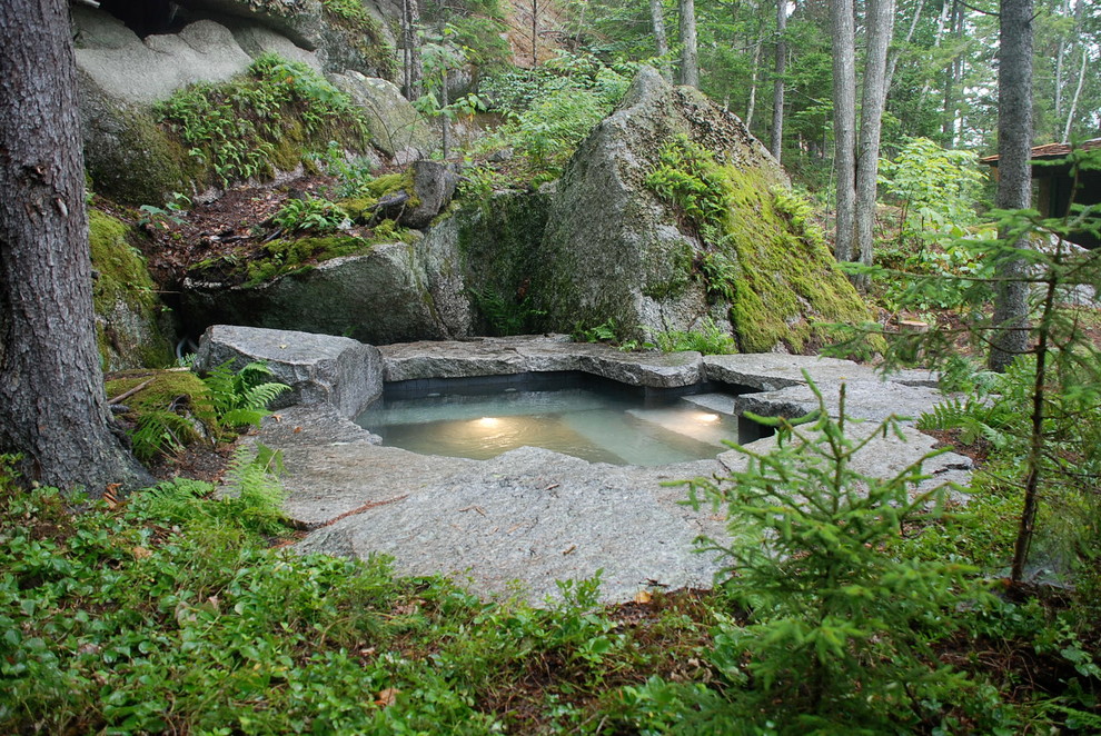 Example of a large mountain style backyard stone and custom-shaped natural hot tub design