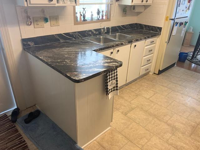 Inspiration for a small galley eat-in kitchen remodel with black backsplash and a peninsula