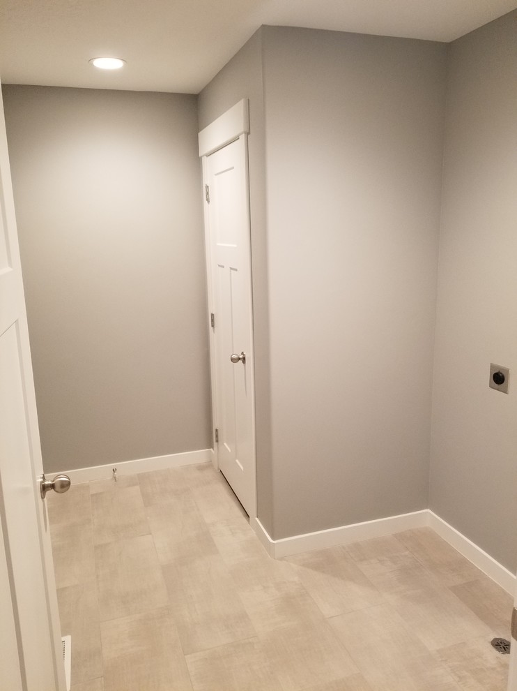 Photo of a mid-sized transitional dedicated laundry room in Salt Lake City with grey walls, porcelain floors, a side-by-side washer and dryer and beige floor.