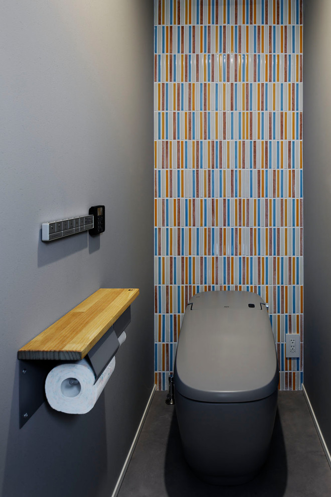 Cette photo montre un WC et toilettes moderne avec WC à poser, un mur gris, un sol en vinyl et un sol gris.
